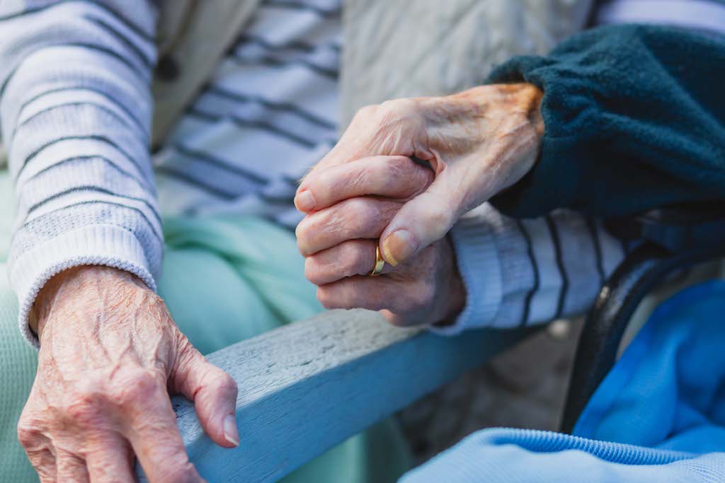 Elderly couple holding hands