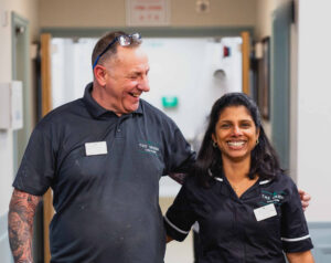 Members of staff walking down home corridor
